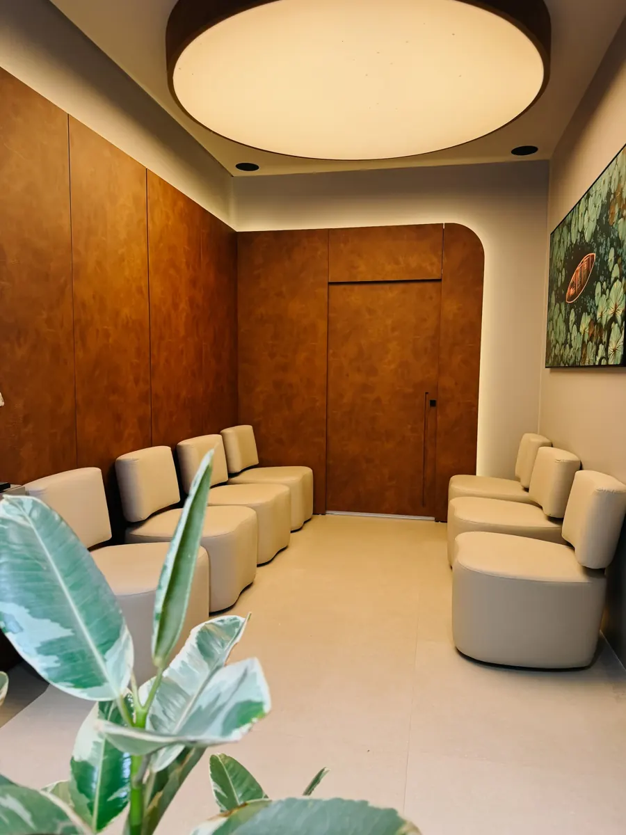 Sala de espera com poltronas claras e iluminação indireta